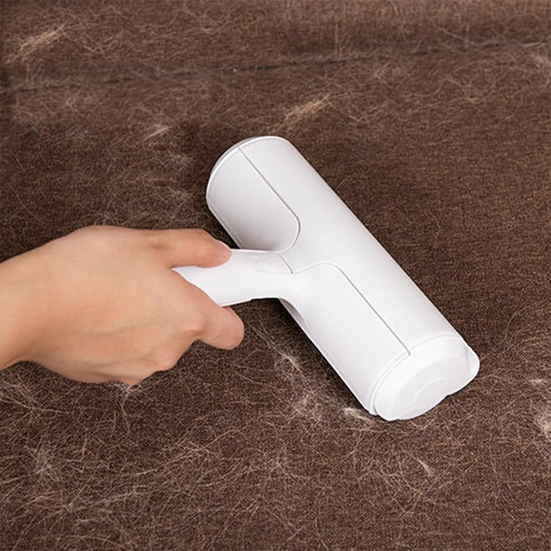 Hand using a white hair removal device on a brown surface with hair.